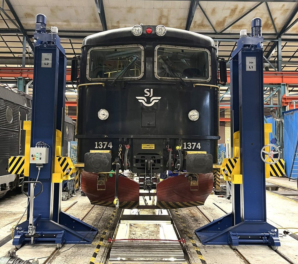 Tågvagn upplyft på synkroniserade lyftbockar i en depå